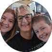 A smiling older woman with short gray hair and glasses poses for a selfie with a young girl and a young boy, all smiling, in what appears to be an indoor setting—perfect for sharing happy testimonials or Citrus Heights dental reviews.