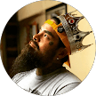 A bearded man wearing a paper crown looks thoughtfully upward. He has tattoos on his face and is indoors with shelves and framed art in the blurred background, as if pondering the latest Citrus Heights dental reviews.